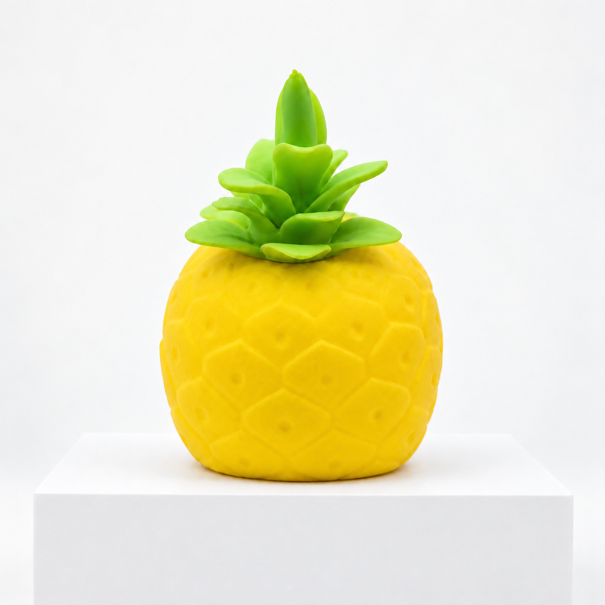 Yellow pineapple-shaped Squeeezy toy with green leaves, unboxed front view
