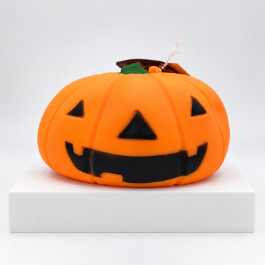 Orange jack-o'-lantern Squeeezy toy with black face, front view