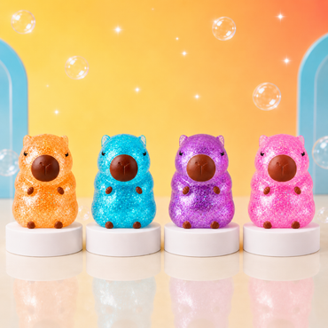 Orange, blue, purple and pink ORB Sugar Capybara glitter squishies on white podiums