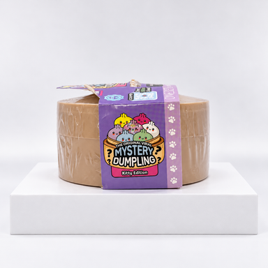 Round tan Mystery Dumpling container showing purple side wrap