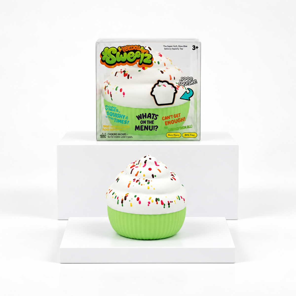 White sprinkle cupcake squishy with green base displayed in front of its box
