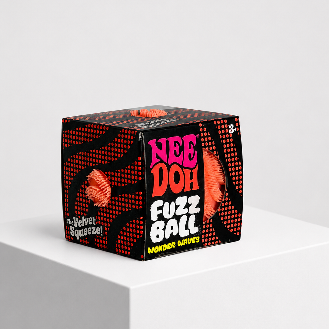 A box of Nee Doh Fuzz Ball Wonder Wipes displayed on a white cube pedestal against a light gray background.