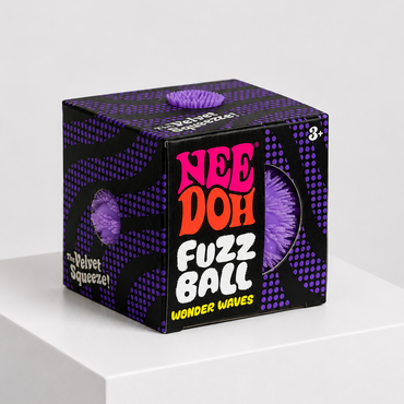 A cube-shaped product box for Nee Doh Fuzz Ball Wonder Waves, featuring a black and purple patterned design with bold pink, orange, and white lettering, displayed on a white pedestal against a light gray background.