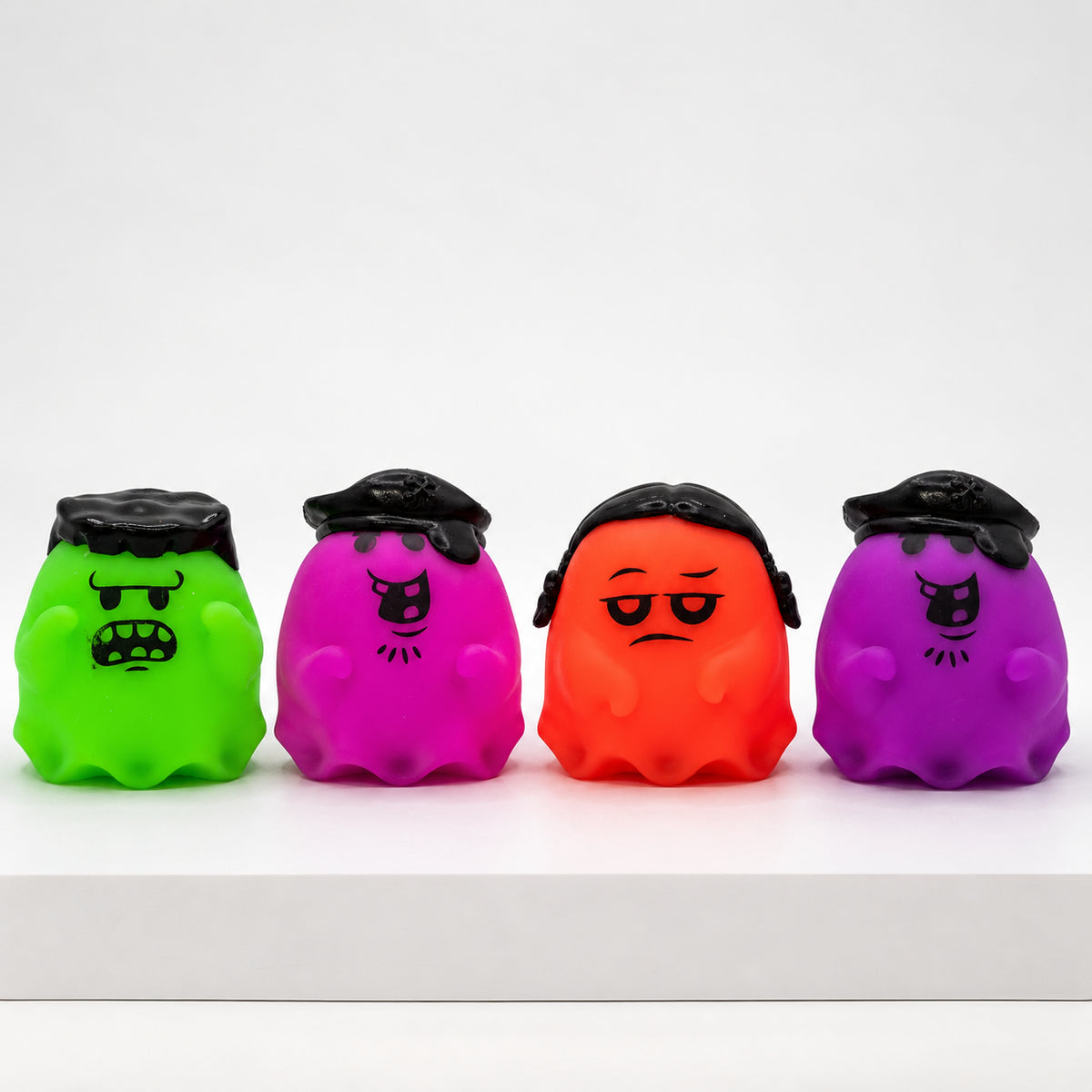 Four NeeDoh Glowy Ghost squishies in green, pink, orange and purple