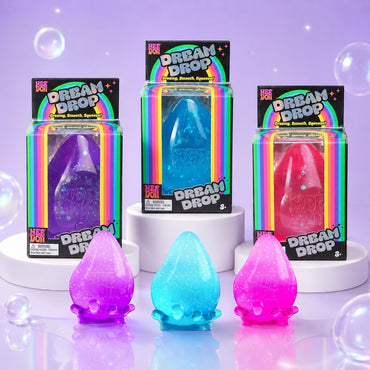 Squish Planet NeeDoh Dream Drop squishy fidget toys in purple, blue, and pink with glitter in their original boxes.