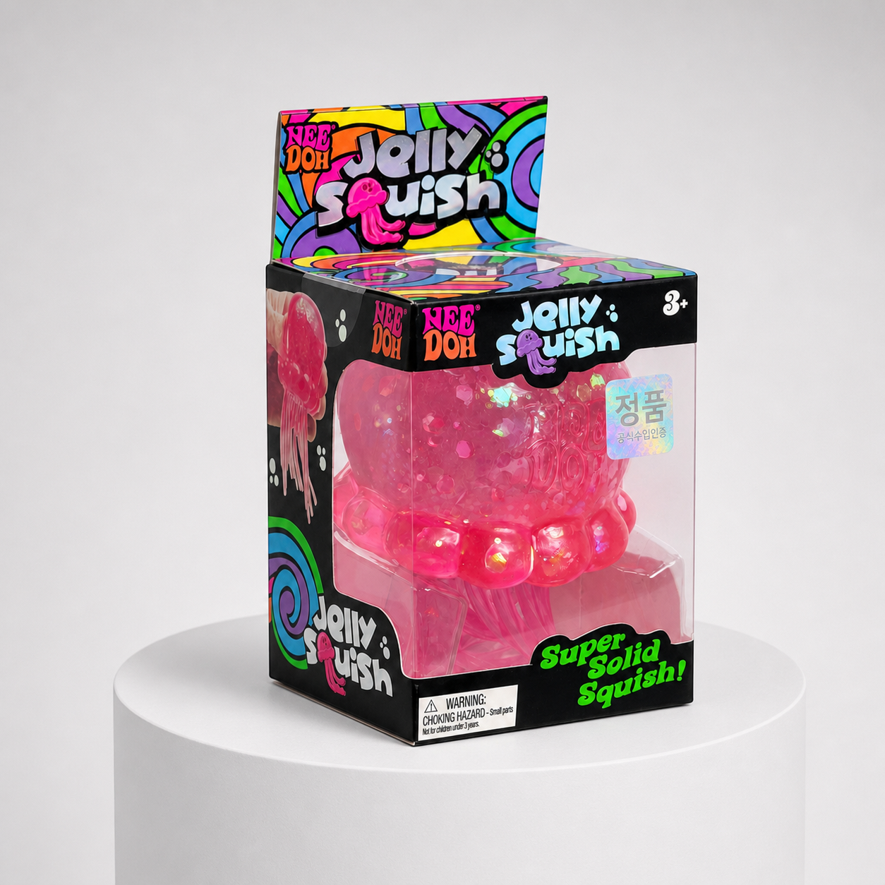 NeeDoh JellySquish pink glitter jellyfish squishy fidget toy in complete retail packaging, centered studio view.
