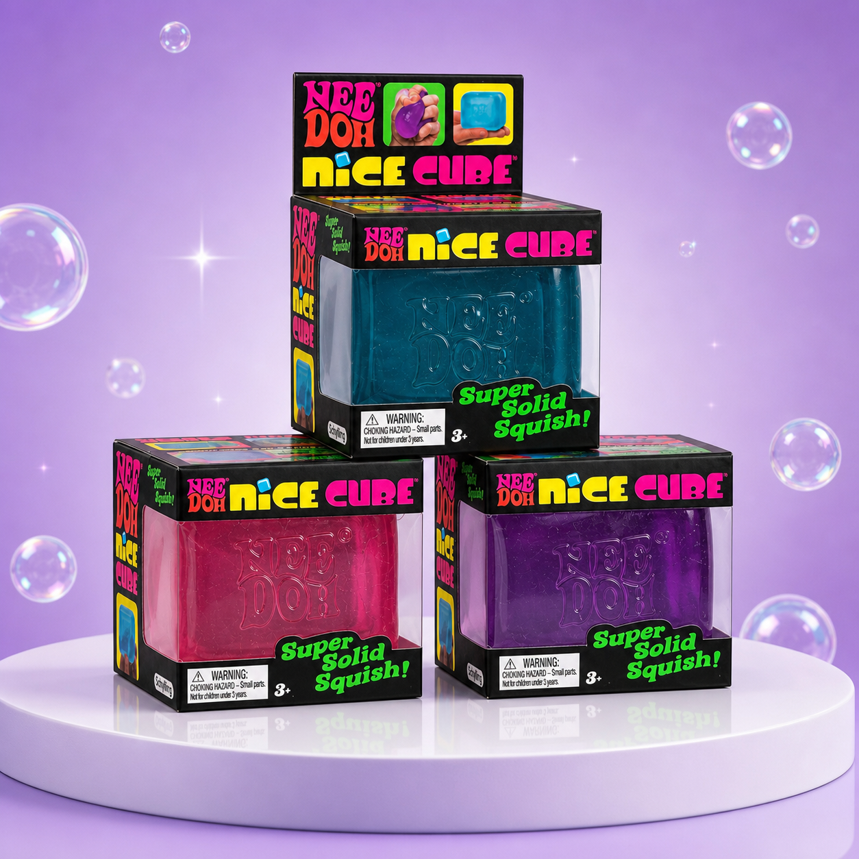NeeDoh Nice Cube blue, pink, and purple squishy fidget toys in complete retail packaging on a Squish Planet purple display.