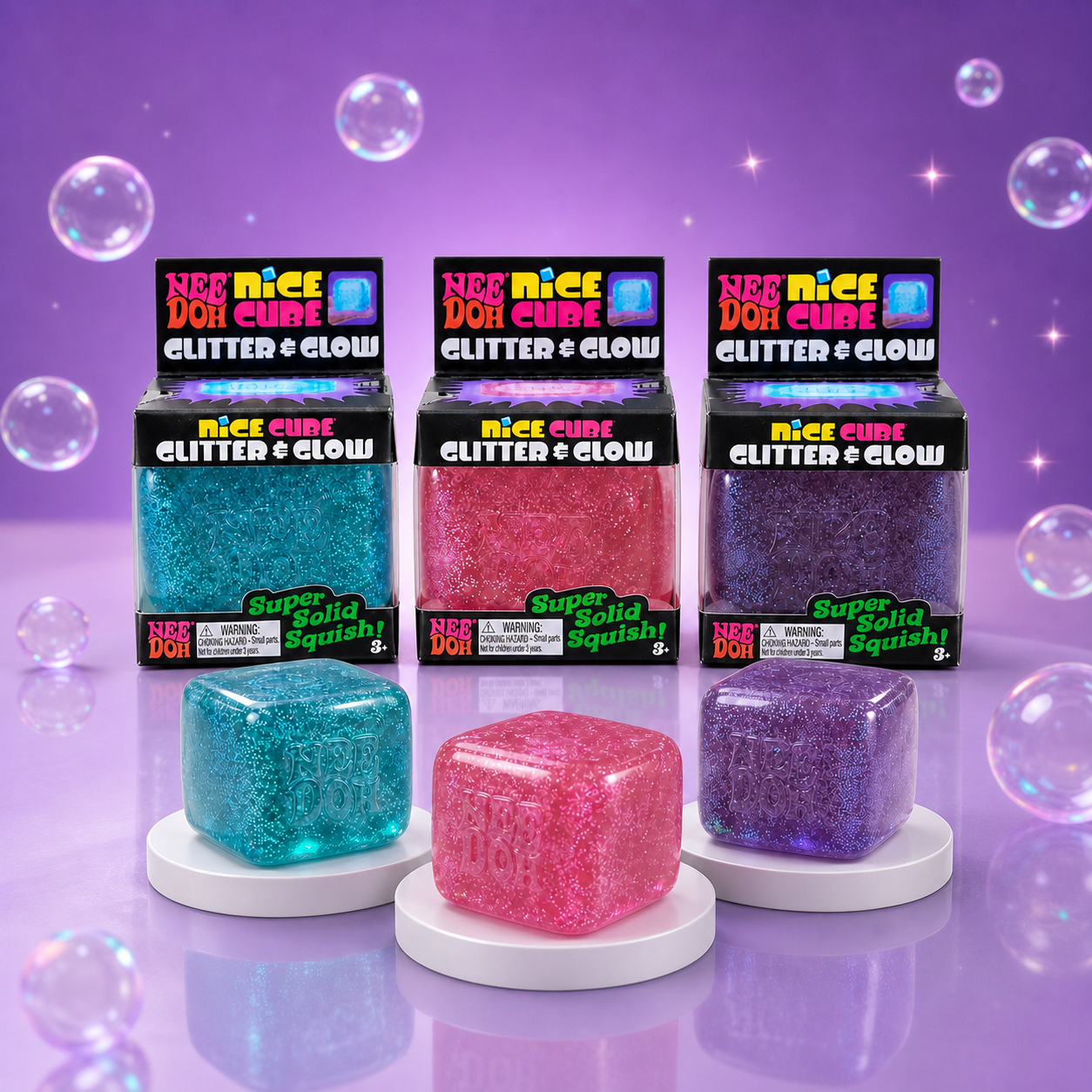 NeeDoh Nice Cube Glitter and Glow packaging with blue, pink, and purple glitter squishy cubes on a Squish Planet purple display.