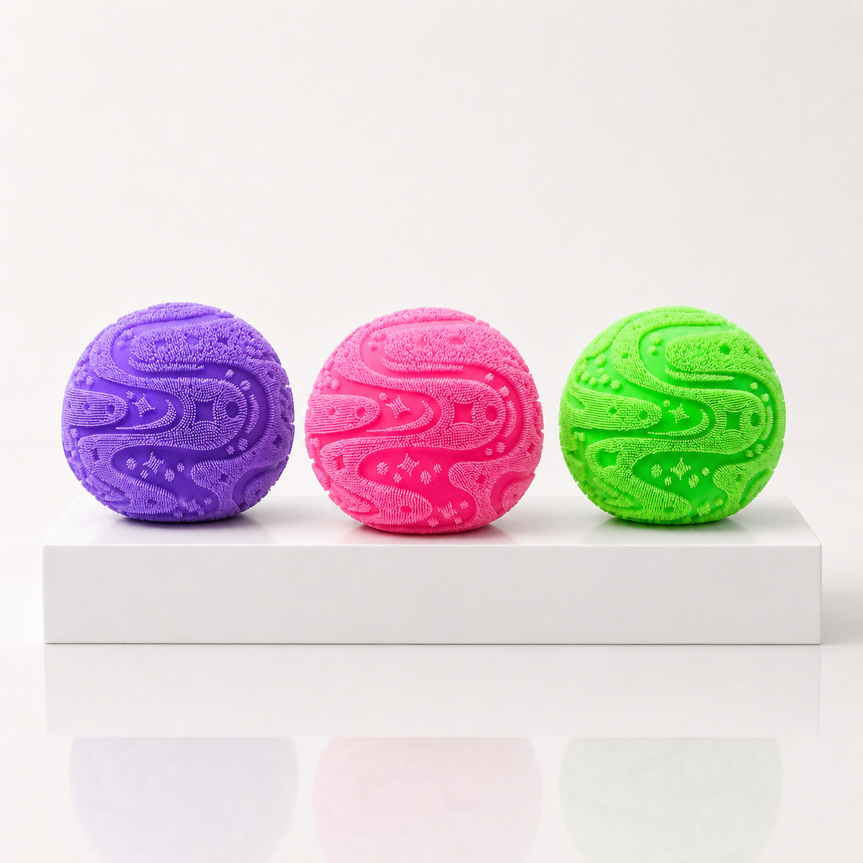 NeeDoh Super Fuzzball toys in purple, pink and green