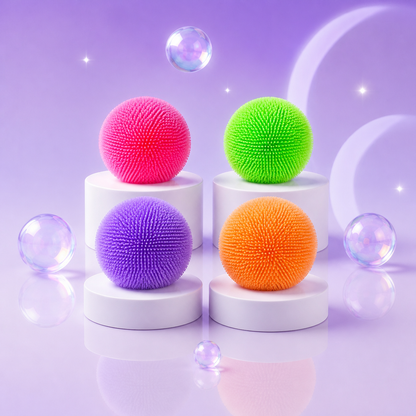 NeeDoh Teenie Fuzz Ball squishy fidget toys in pink, green, purple, and orange on a Squish Planet purple display.
