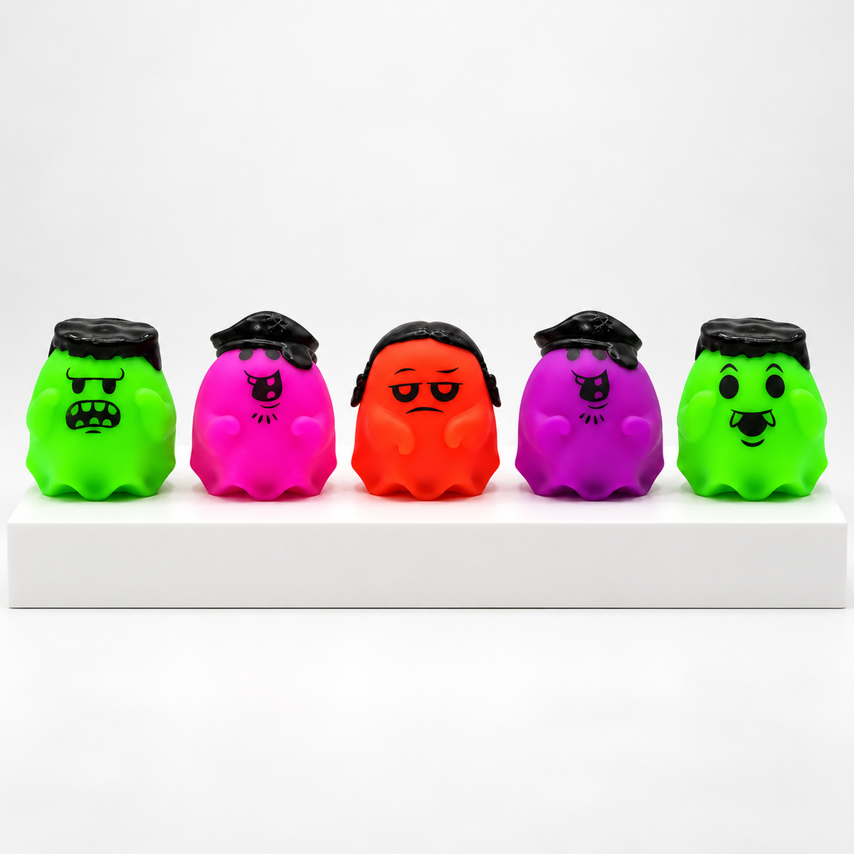 Five unboxed green, pink, orange and purple NeeDoh Glowy Ghost toys in a row