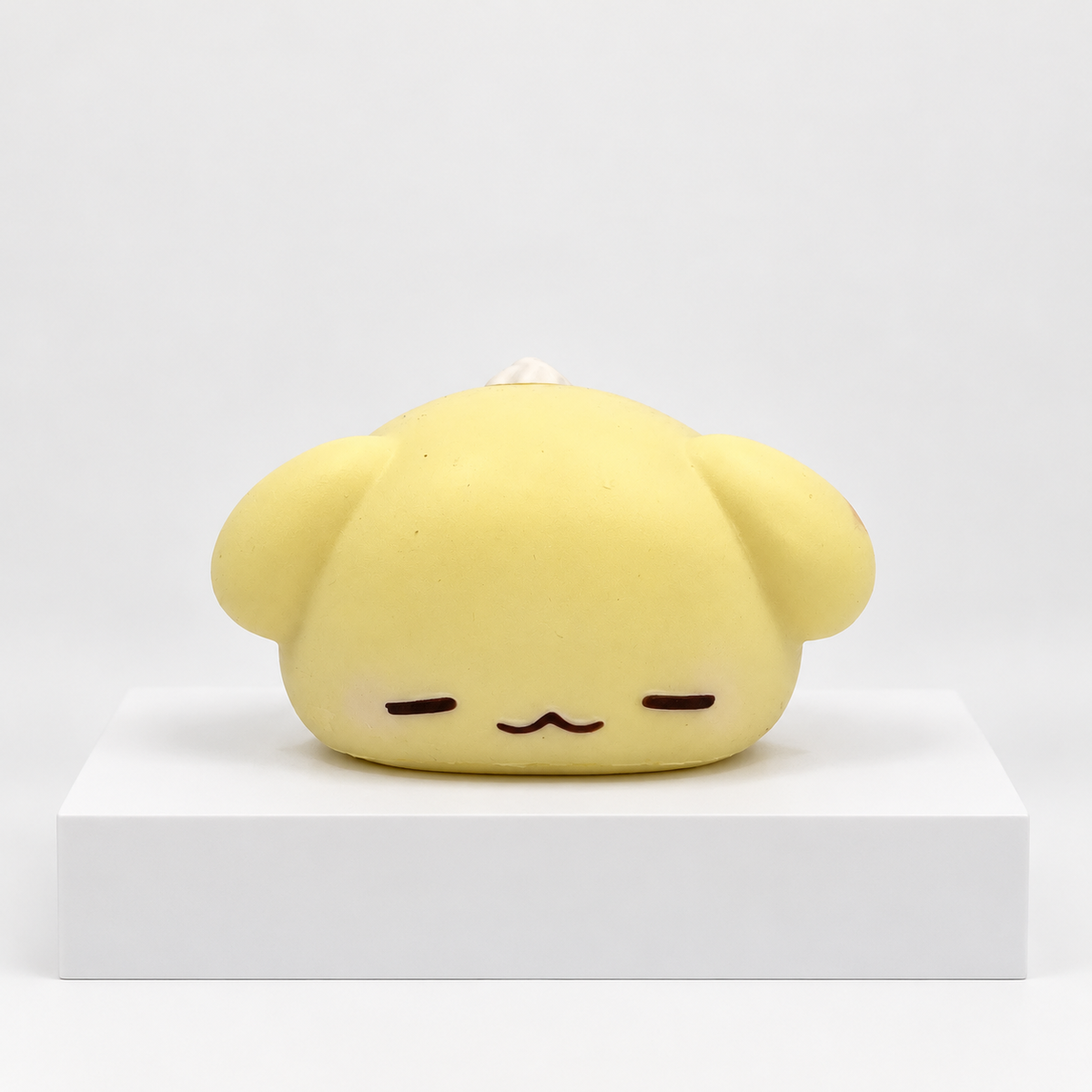 Cream-yellow Nunu puppy character lying down, front view
