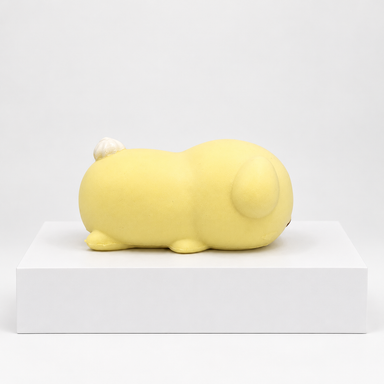 Cream-yellow Nunu puppy character lying down, side view