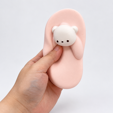 Hand holding the pink Nunu bear slipper-shaped toy