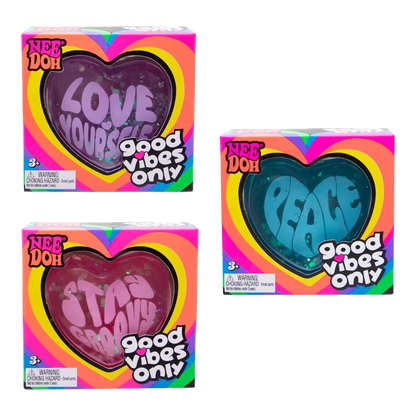 Squish Planet NeeDoh Good Vibes Only fidget toys in heart shapes: 'Love Yourself' (purple), 'Peace' (blue), and 'Stay Groovy' (pink).