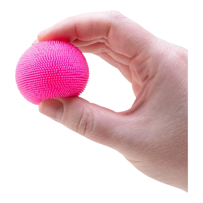 Squish Planet NeeDoh Teenie Fuzz Ball, a small, bright pink, spiky textured squishy fidget toy held in a hand.