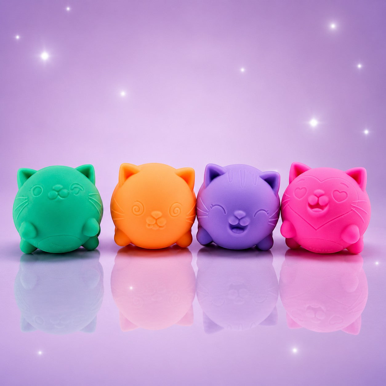 Squish Planet NeeDoh Cool Cat squishy fidget toys in teal, orange, purple, and pink on a reflective surface.
