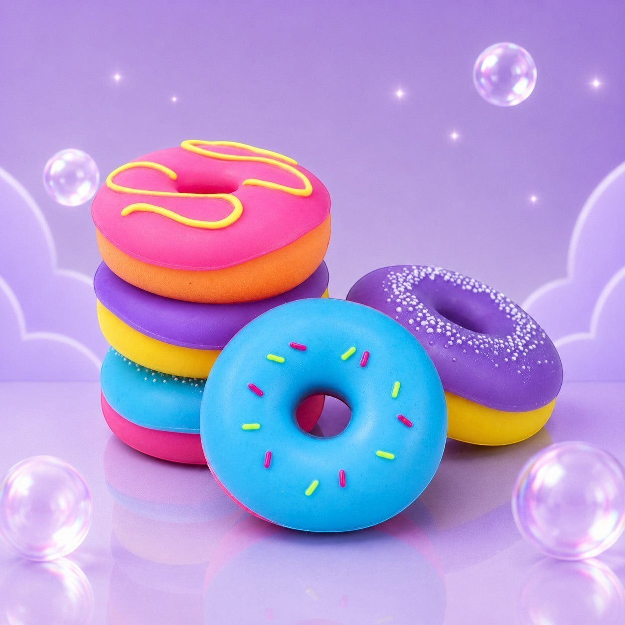 Squish Planet NeeDoh Dohnuts squishy fidget toys in bright pink, blue, and purple donut shapes with colorful sprinkles.