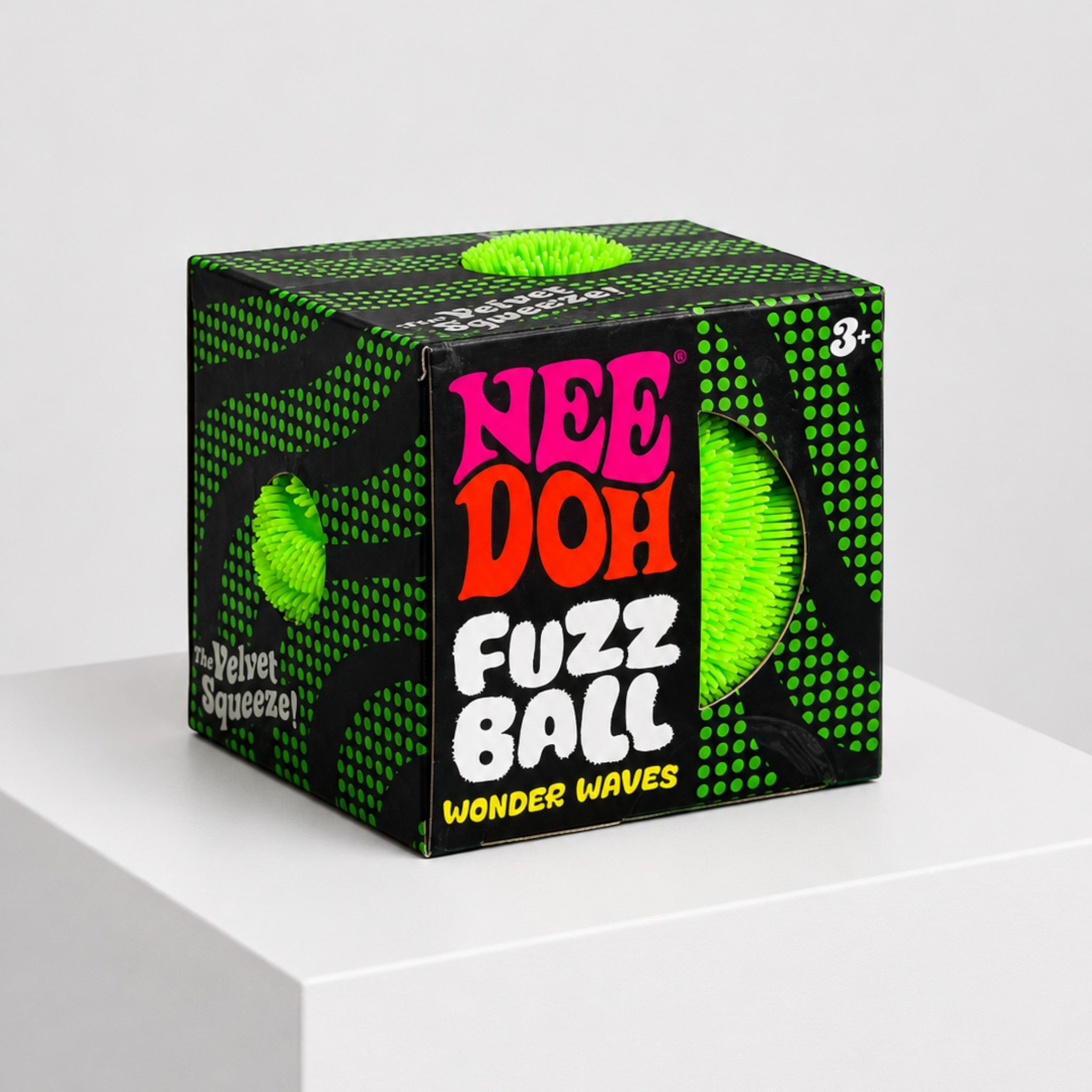Squish Planet NeeDoh Fuzz Ball velvet squeeze fidget toy in bright neon green inside its black and green display box.