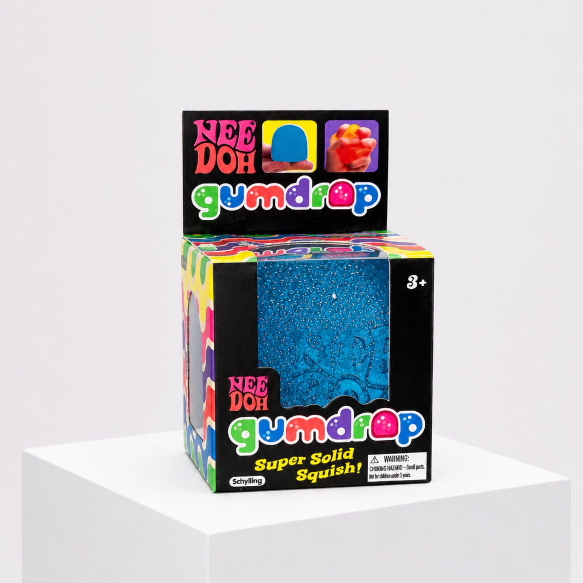 Squish Planet NeeDoh Gumdrop blue squishy fidget toy in its colorful retail packaging box on a white pedestal.