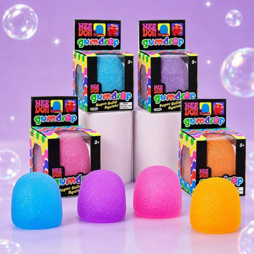 Squish Planet NeeDoh Gumdrop fidget toys in blue, purple, pink, and orange with matching retail display boxes.