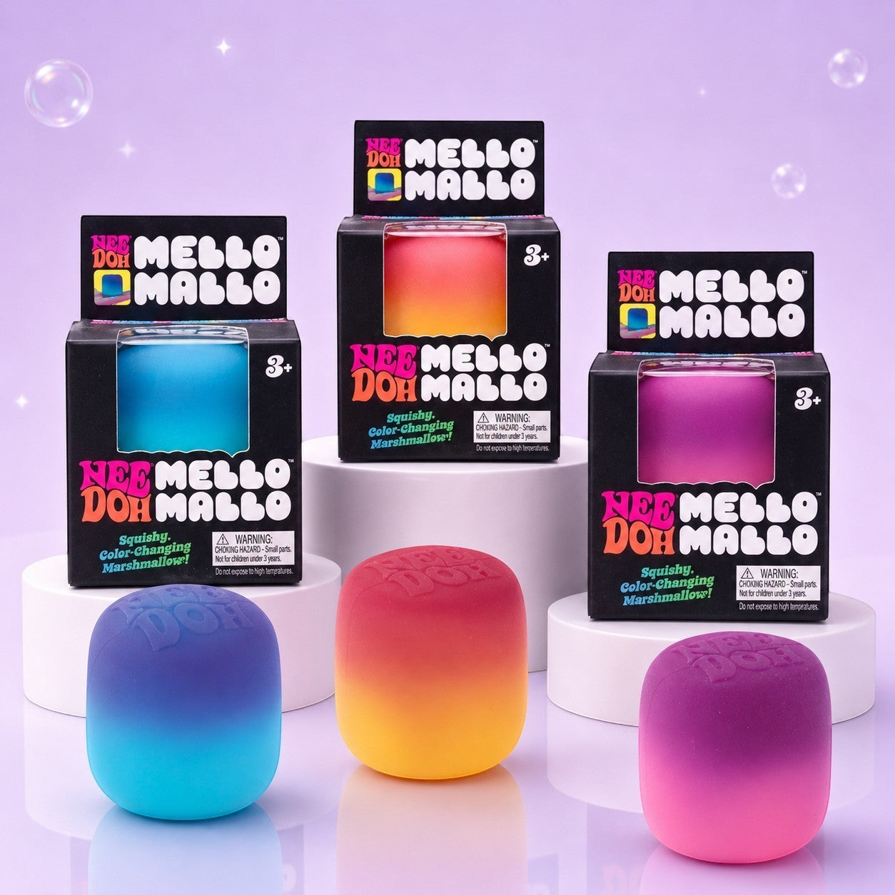 Squish Planet NeeDoh Mello Mallo color-changing squishy fidget toys in blue, orange, and pink on white pedestals.