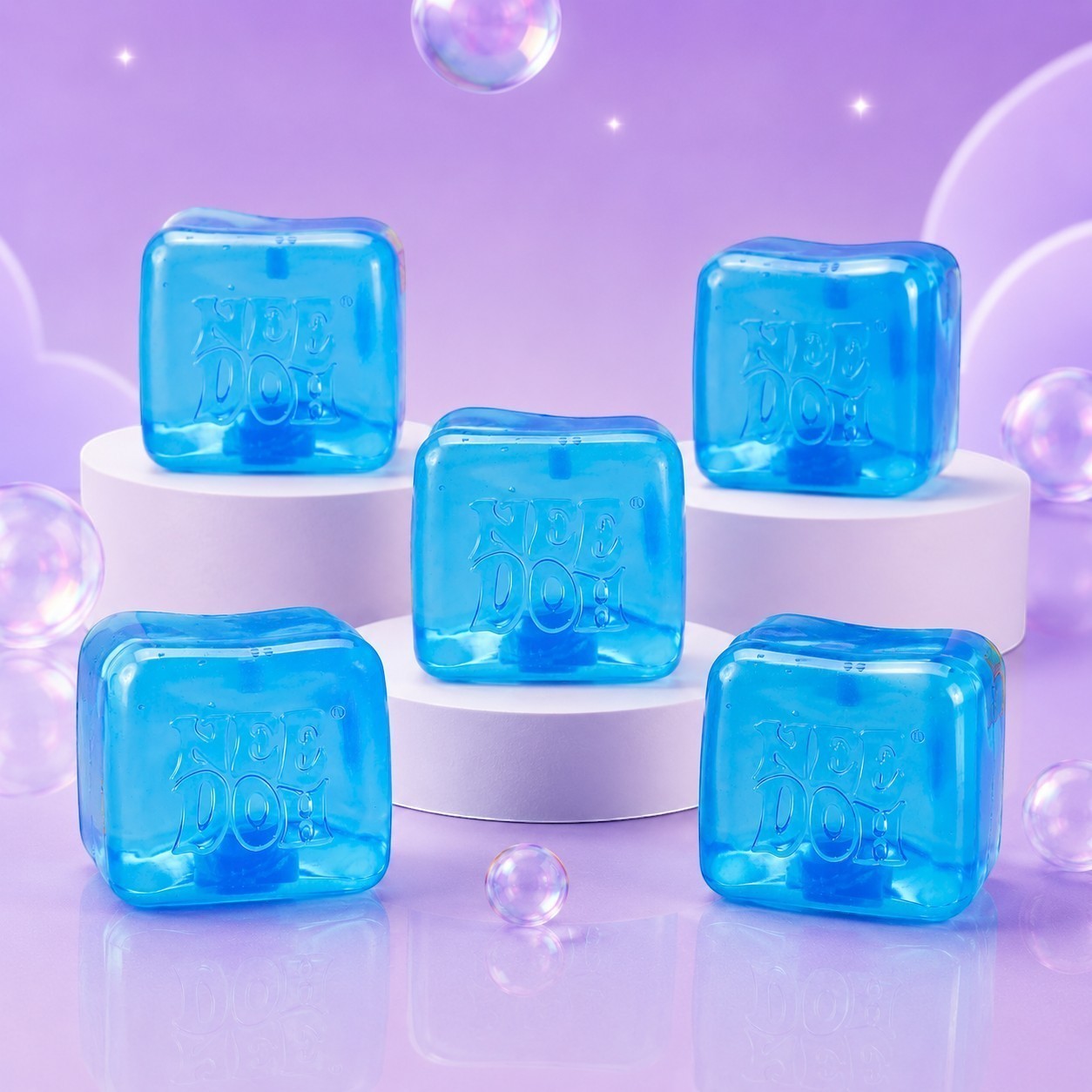 Squish Planet NeeDoh Nice Berg translucent blue ice-cube shaped squishy fidget toys on white display pedestals.