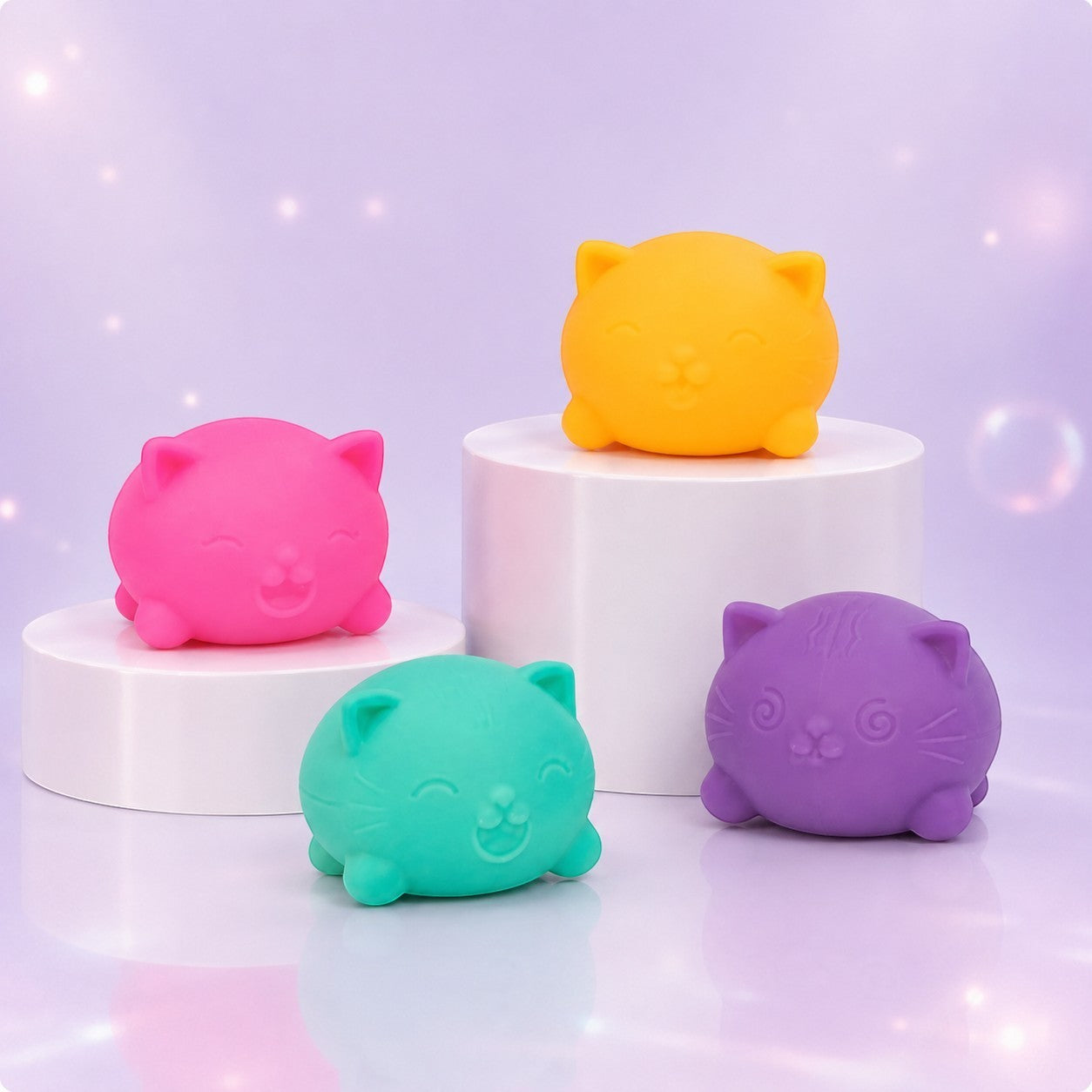 Squish Planet NeeDoh Teenie Cool Cat squishy fidget toys in pink, yellow, teal, and purple on white display stands.