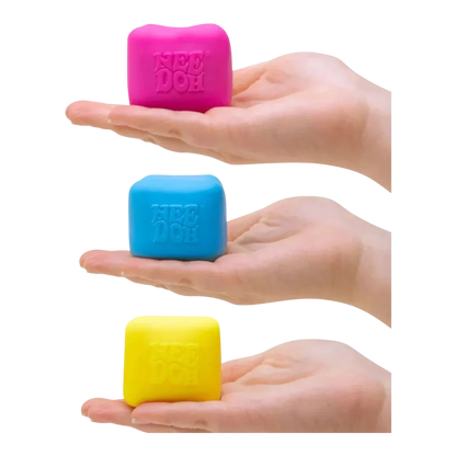 Squish Planet NeeDoh Color Changing Cube squishy fidget toy in pink, blue, and yellow, held in hands.