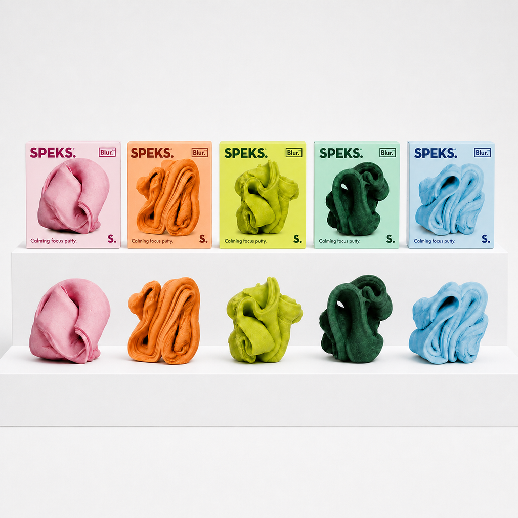 Speks Blur Focus Putty in five colors with matching boxes on a neutral white studio background