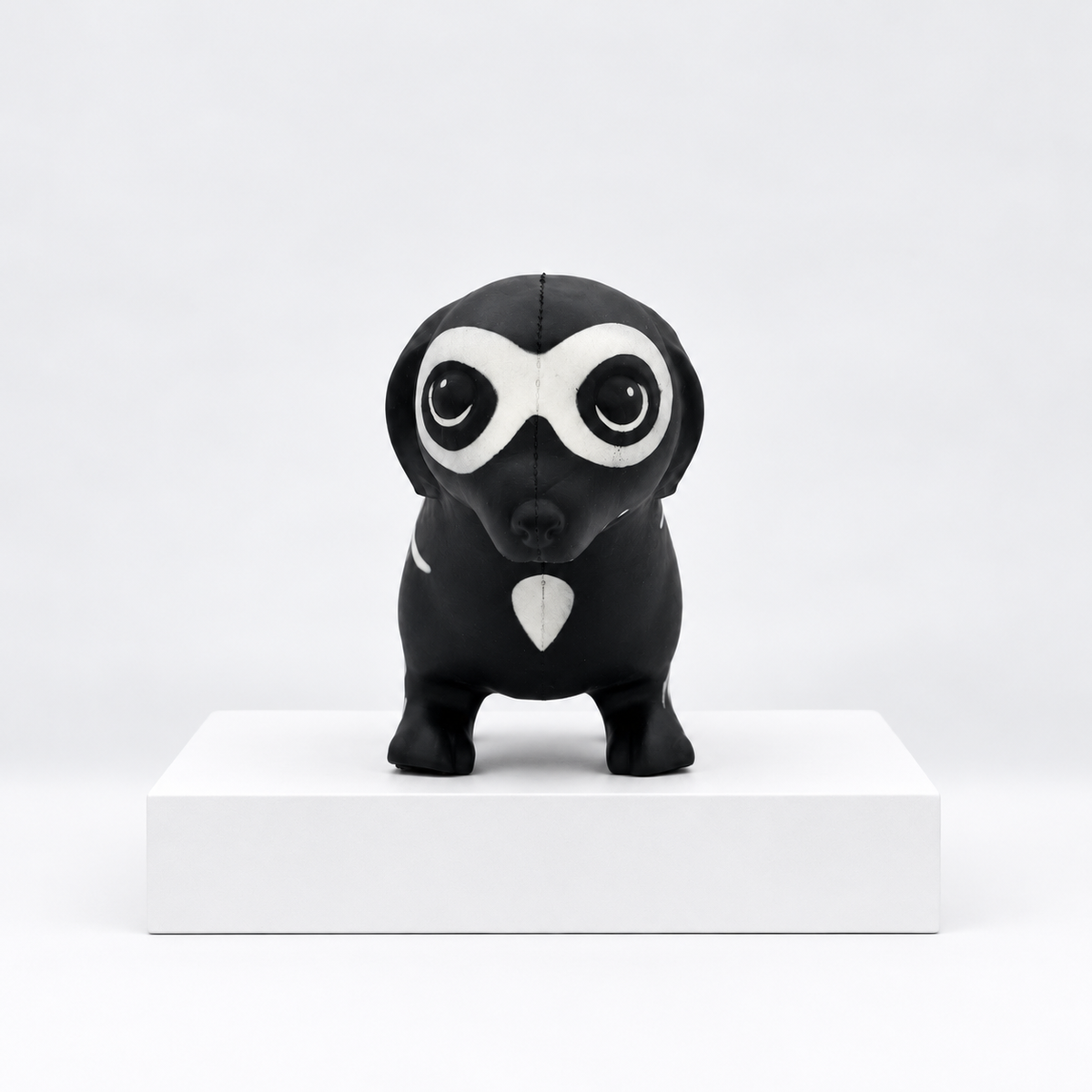 Black owl-shaped toy with white eye markings, front view
