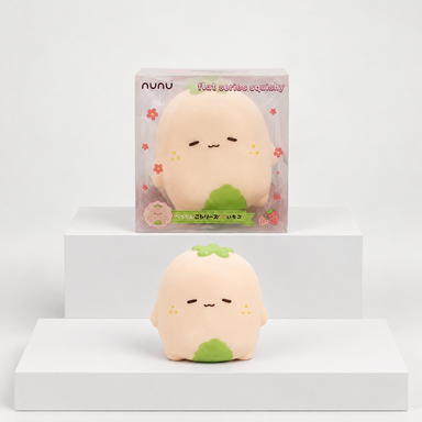 Pale pink Nunu strawberry character with green details displayed beneath its box