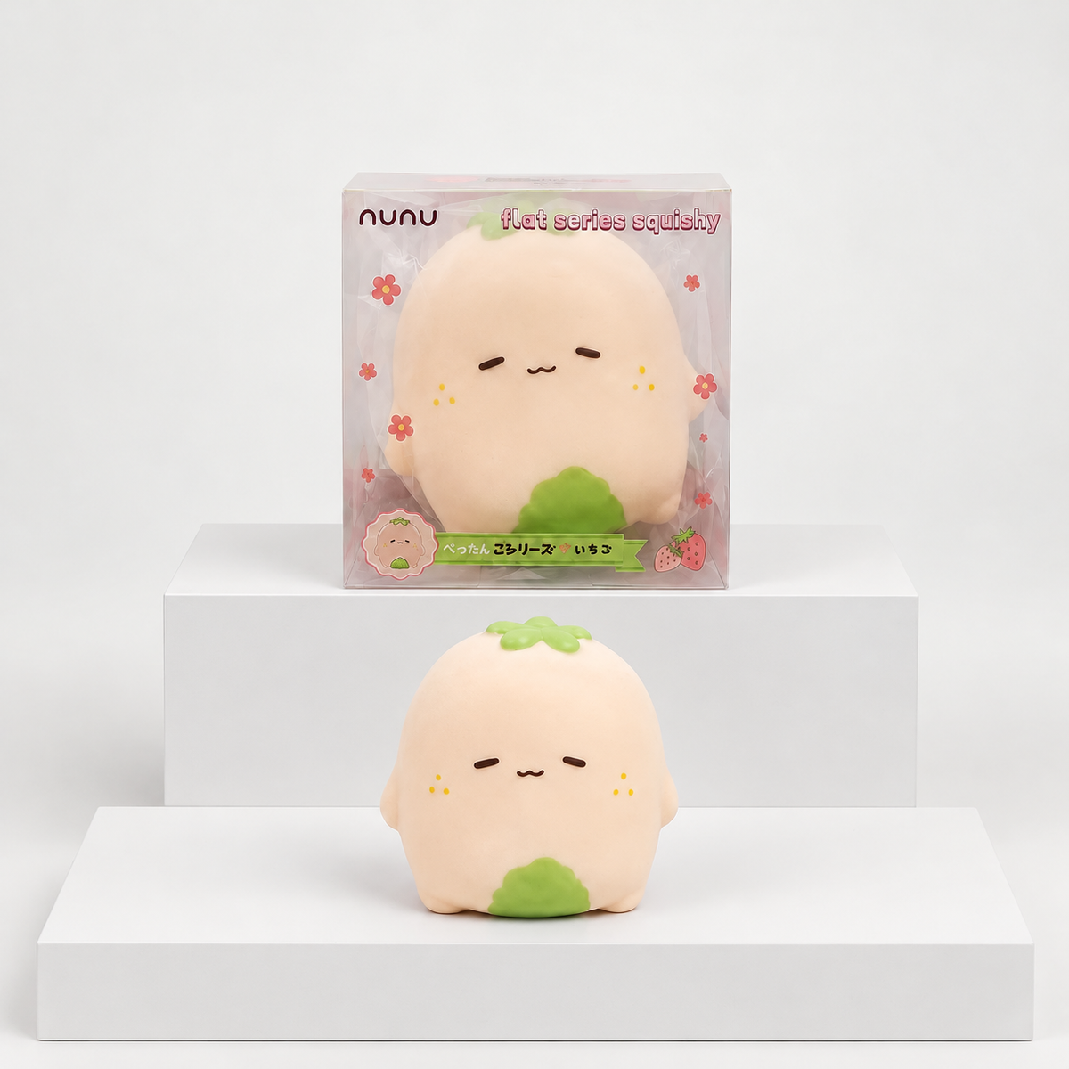 Pale pink Nunu strawberry character with green details displayed beneath its box