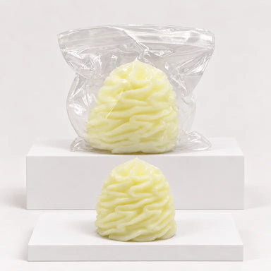 Pale-yellow whipped-cream-shaped squishy with clear wrapper behind it