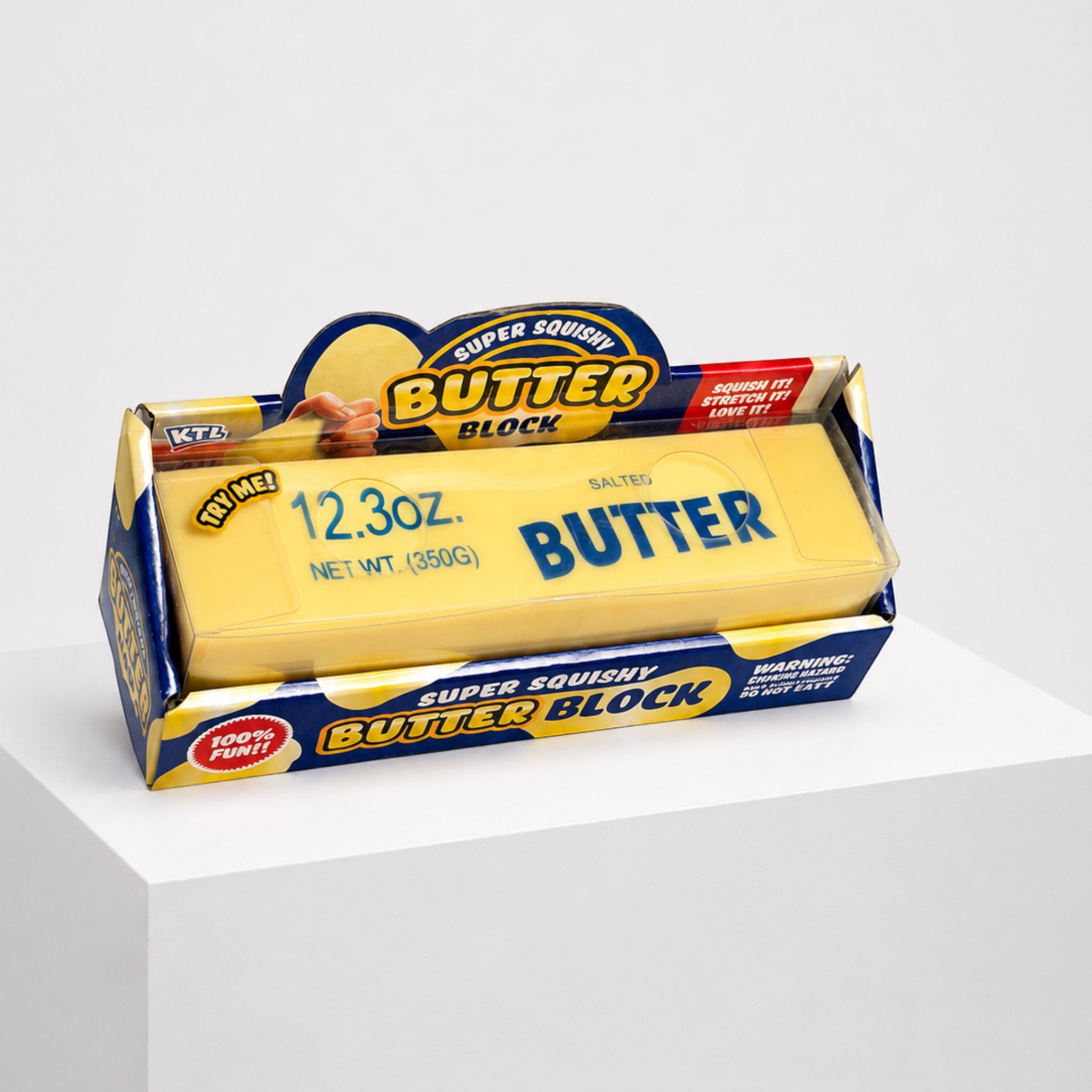 Squish Planet KTL jumbo dough-filled butter block squishy toy in its original yellow and blue retail packaging.